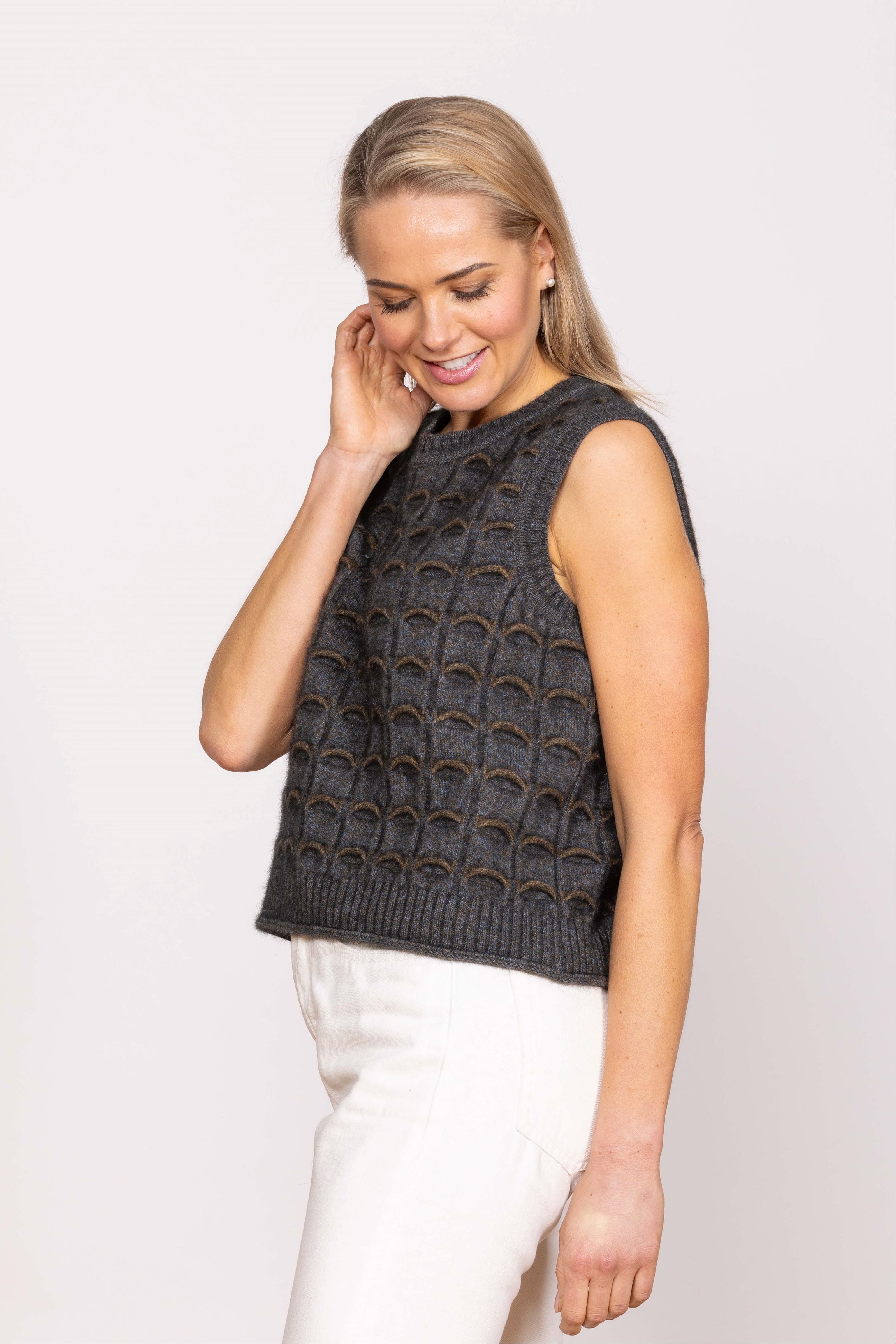 A woman wearing a sleeveless, V-neck Noble Wilde possum merino eyelash vest in color pattern.